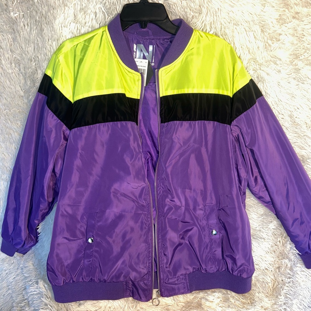 Plus size purple, black and neon green jacket with a silver zipper.